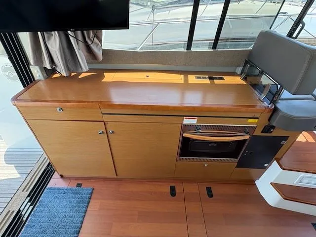 Slide: The Image of Interior of 2013 Jeanneau NC11 boat with wooden cabinetry and seating. - 5