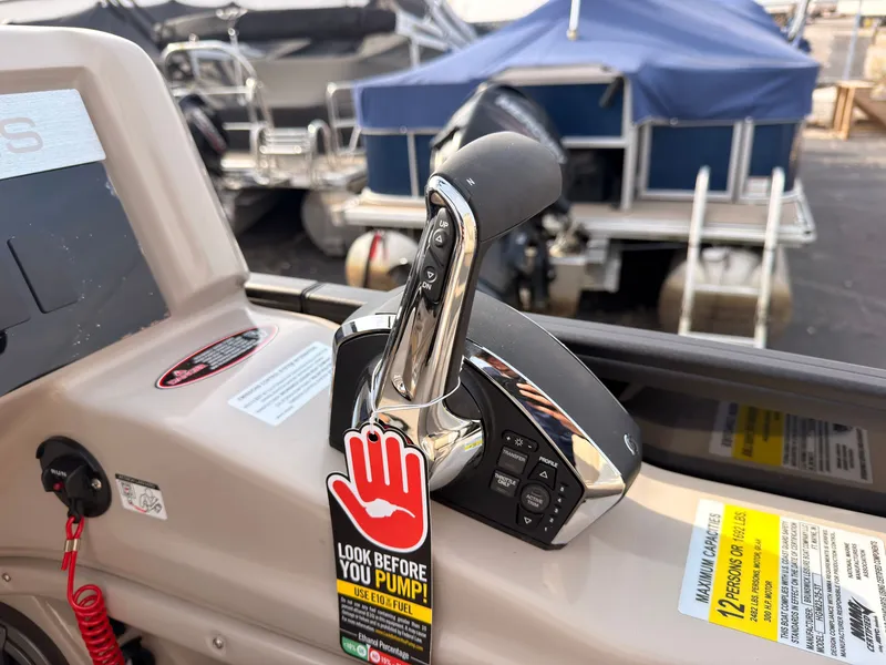 Slide: The Image of Close-up of a boat throttle with a warning tag, surrounded by other boats in the background. - 31