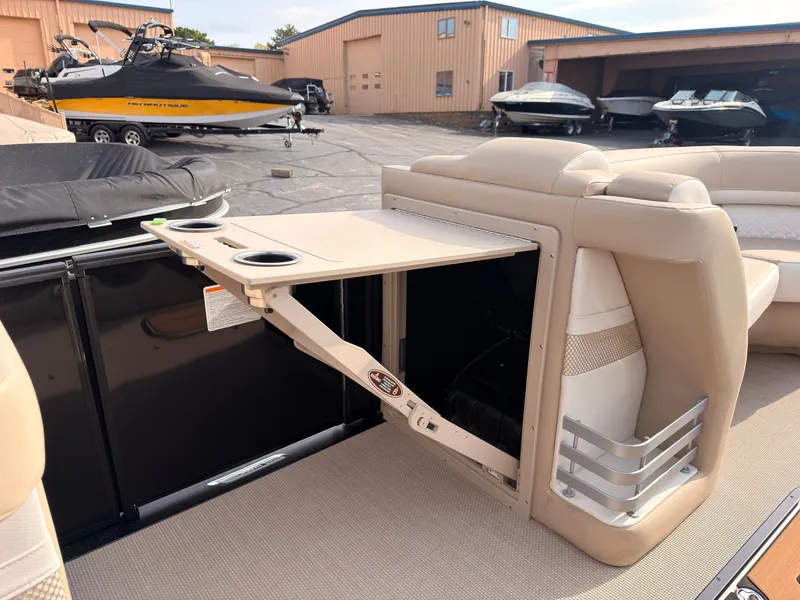 Slide: The Image of A foldable table with cup holders on a boat, surrounded by beige seating. - 25