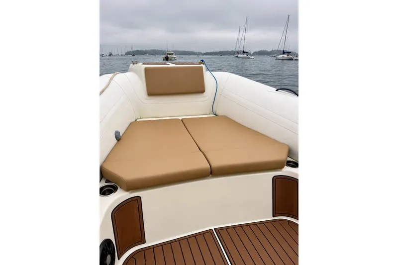 Slide: The Image of 2021 Brig Eagle 10 boat with tan cushions and wooden deck, anchored on a calm lake. - 8