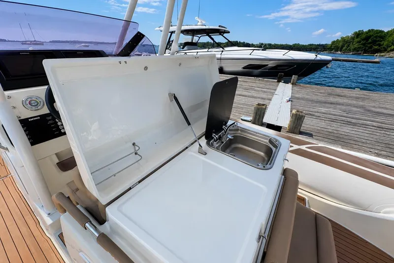 Slide: The Image of 2021 Brig Eagle 10 boat with open kitchenette and sink, docked by the water. - 14