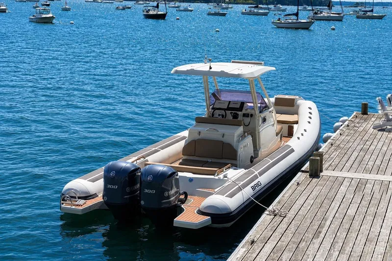 Slide: The Image of 2021 Brig Eagle 10 boat docked, featuring dual Yamaha 300 engines, on a sunny day. - 11