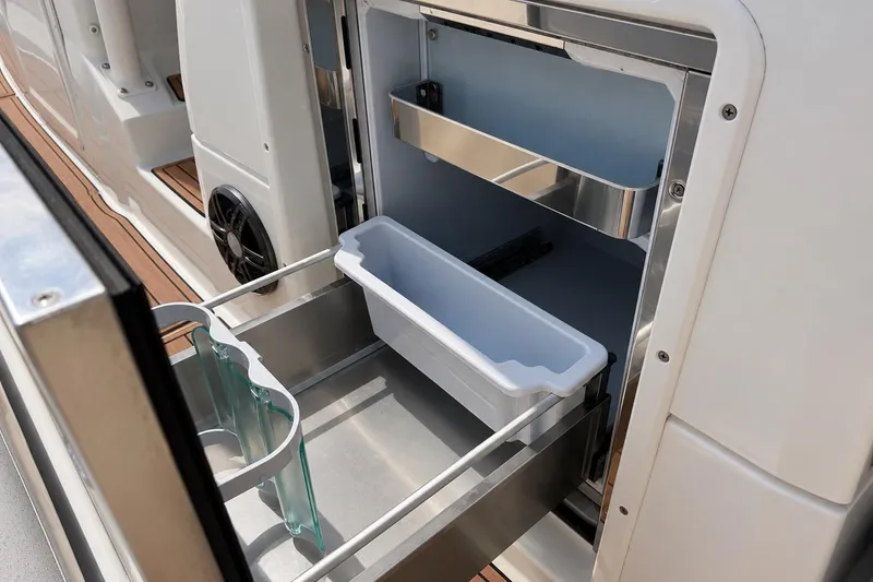 Slide: The Image of Open storage compartment on 2021 Brig Eagle 10 boat with built-in drawer and container. - 21