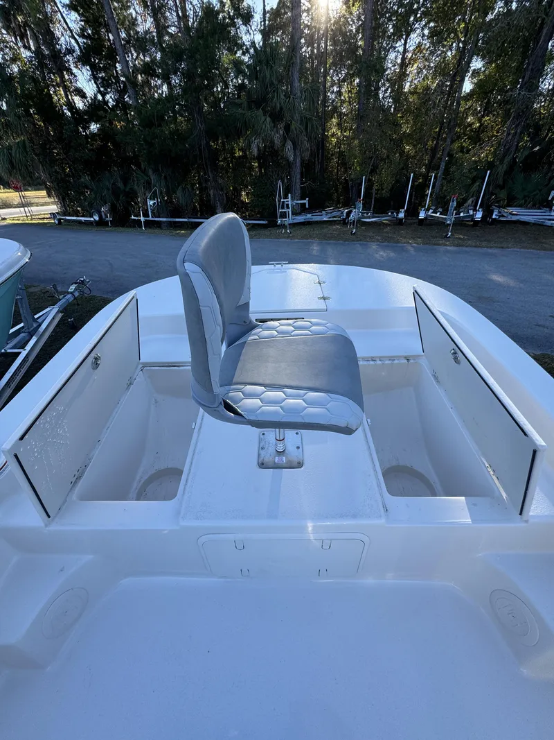 Slide: The Image of A 2026 Carolina Skiff 23 LS with a gray seat on the deck, surrounded by trees. - 19
