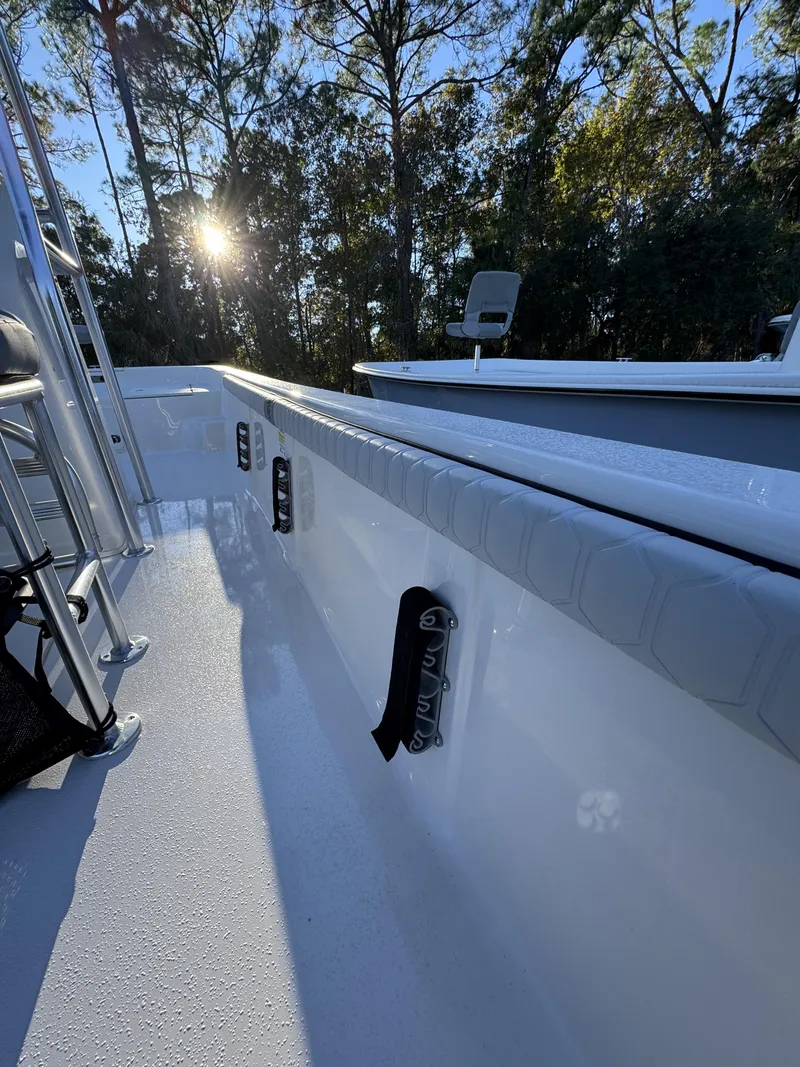 Slide: The Image of A modern boat with a white deck and padding. Sunlight shines through trees in the background. - 8