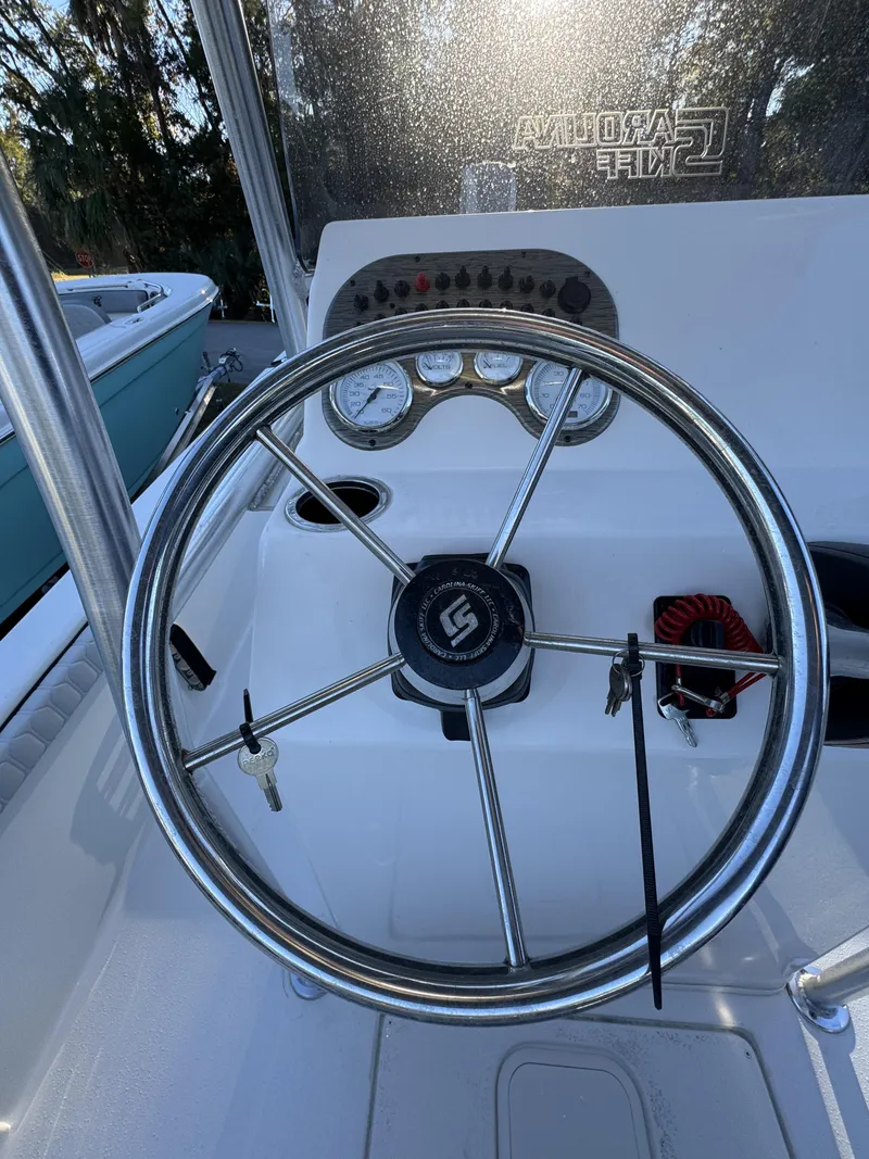 Slide: The Image of The image shows the helm of a Carolina Skiff 23 LS boat with instruments and steering wheel. - 14