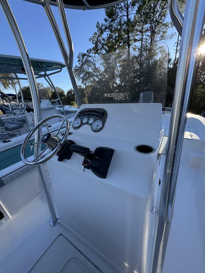 Slide: The Image of The image shows the helm of a Carolina Skiff 23 LS boat with a steering wheel and gauges. - 11