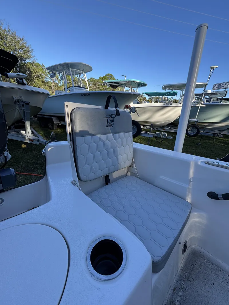 Slide: The Image of A seating area on a Carolina Skiff 23 LS boat, surrounded by other boats outdoors. - 4
