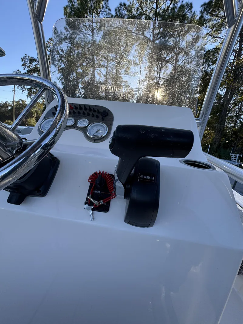 Slide: The Image of The image shows the helm of a Carolina Skiff 23 LS boat with steering wheel and instruments. - 13