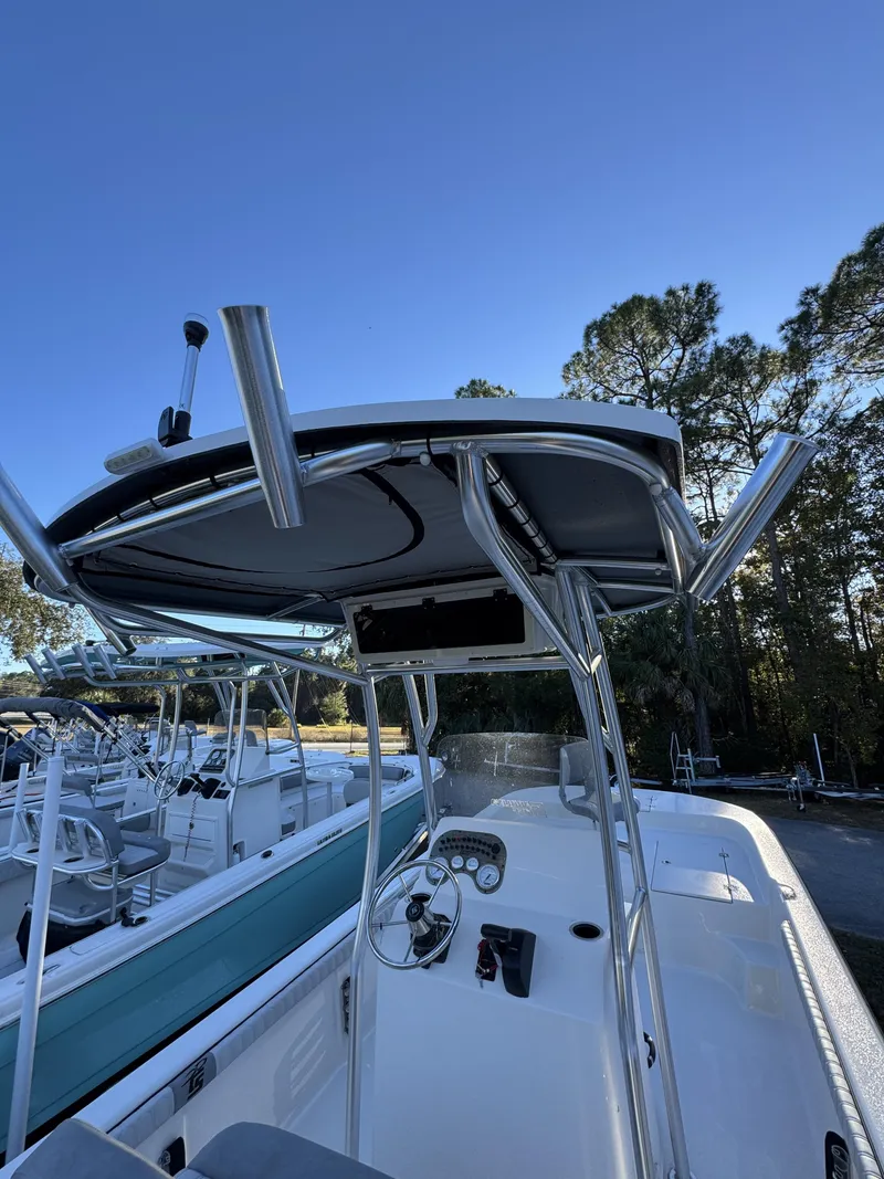 Slide: The Image of The image shows a Carolina Skiff 23 LS boat with a T-top and helm console. - 7