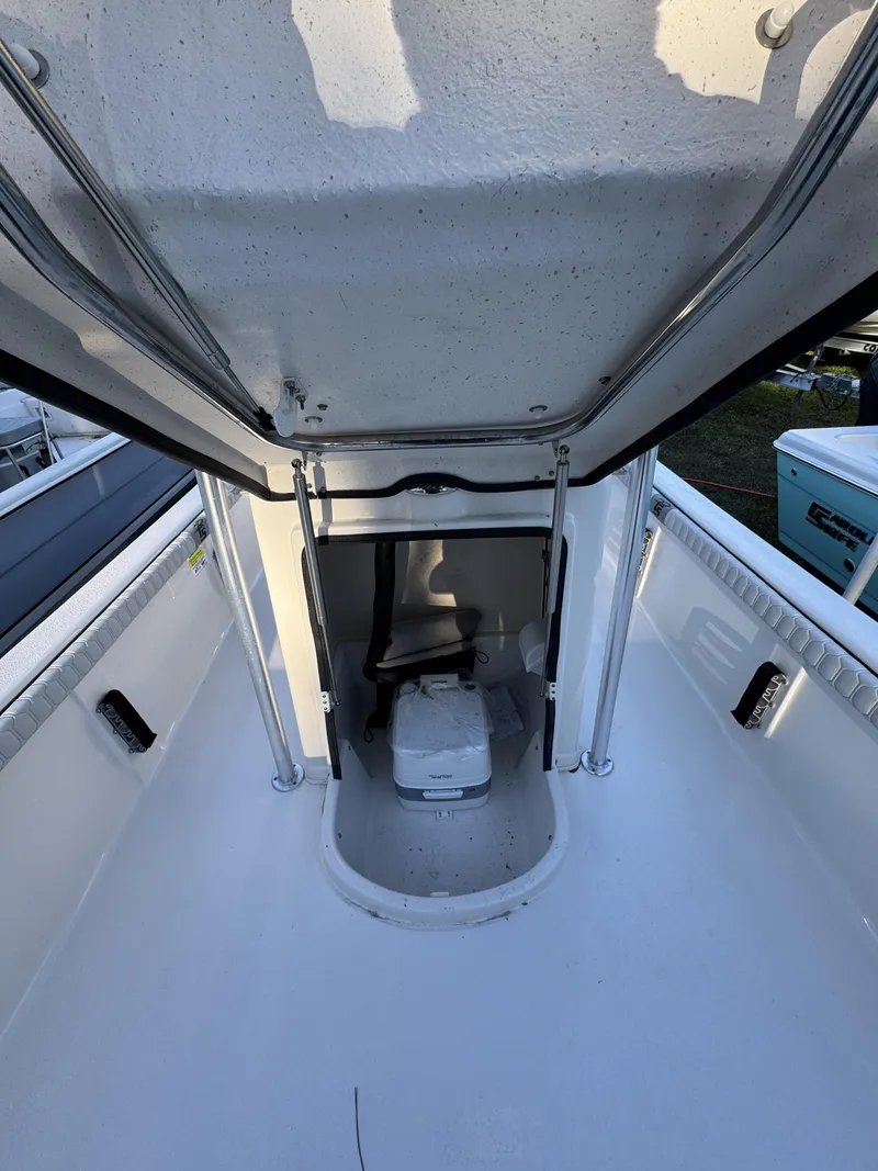 Slide: The Image of The image shows the interior of a Carolina Skiff 23 LS boat with a toilet. - 18