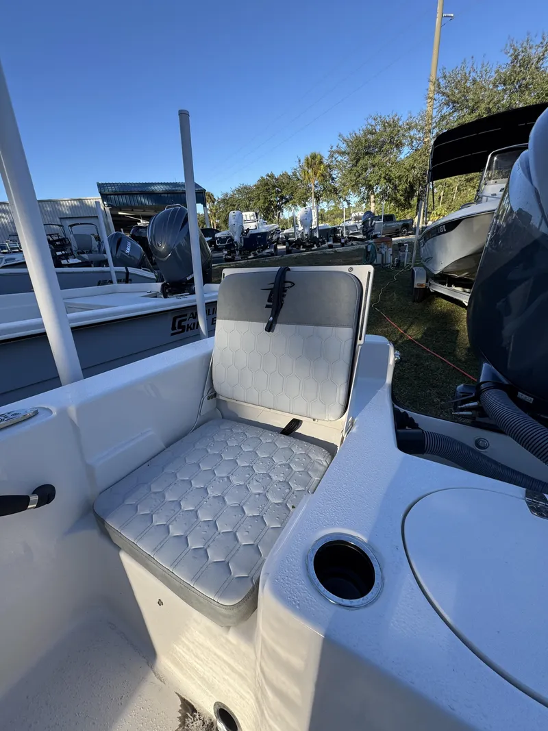 Slide: The Image of A seating area on a Carolina Skiff 23 LS boat, surrounded by other boats outdoors. - 2