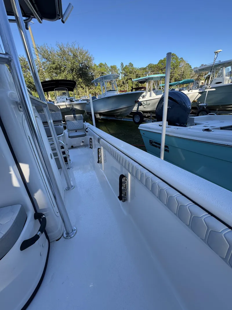 Slide: The Image of A modern dock with several boats, including a Carolina Skiff 23 LS, under clear skies. - 21