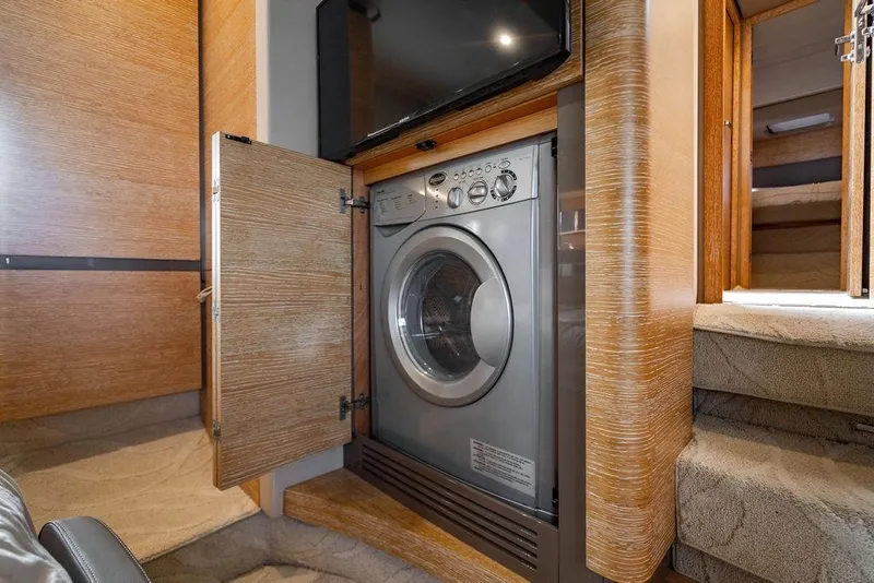 Slide: The Image of Laundry area inside a 2016 Azimut 50 yacht, featuring a built-in washing machine. - 26