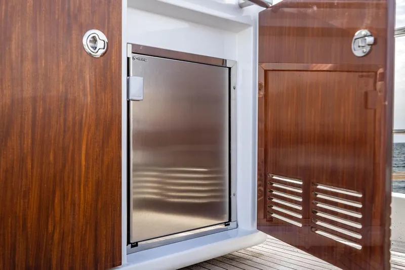 Slide: The Image of Stainless steel fridge on 2016 Azimut 50 yacht, with wooden cabinet doors open. - 37