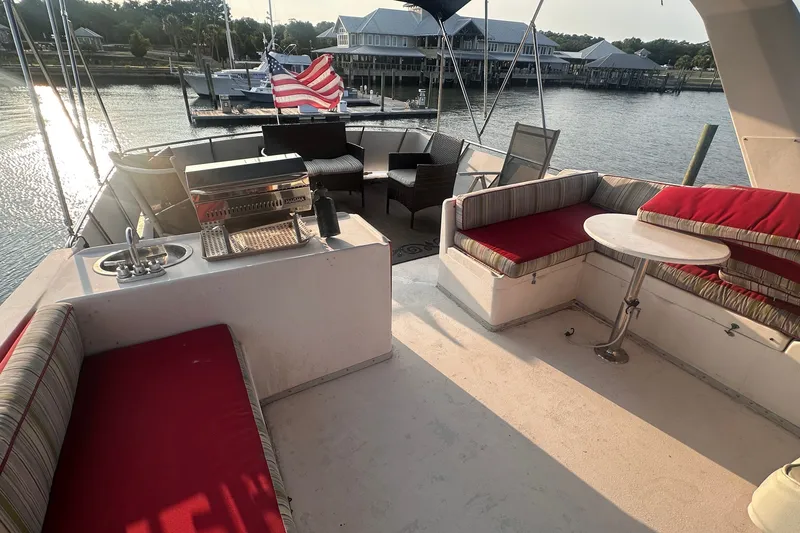 Slide: The Image of 1989 Jefferson Marquessa 52 yacht deck with seating, grill, and American flag. - 46