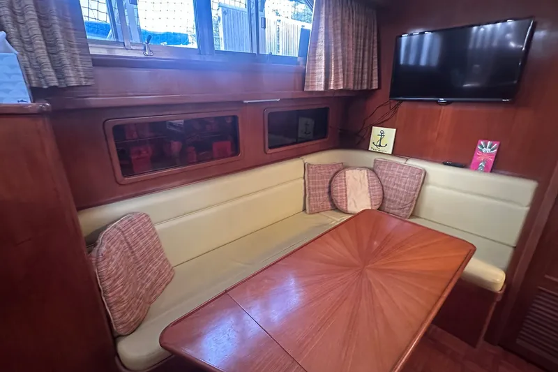 Slide: The Image of Cozy dining area in 1989 Jefferson Marquessa 52 yacht with wood table and cushioned seating. - 17