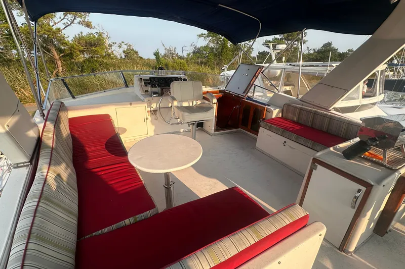 Slide: The Image of Spacious deck of 1989 Jefferson Marquessa 52 with red cushioned seating and helm. - 45