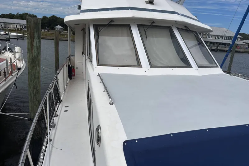 Slide: The Image of 1989 Jefferson Marquessa 52 Extended Deckhouse yacht docked at marina, showcasing sleek design. - 6