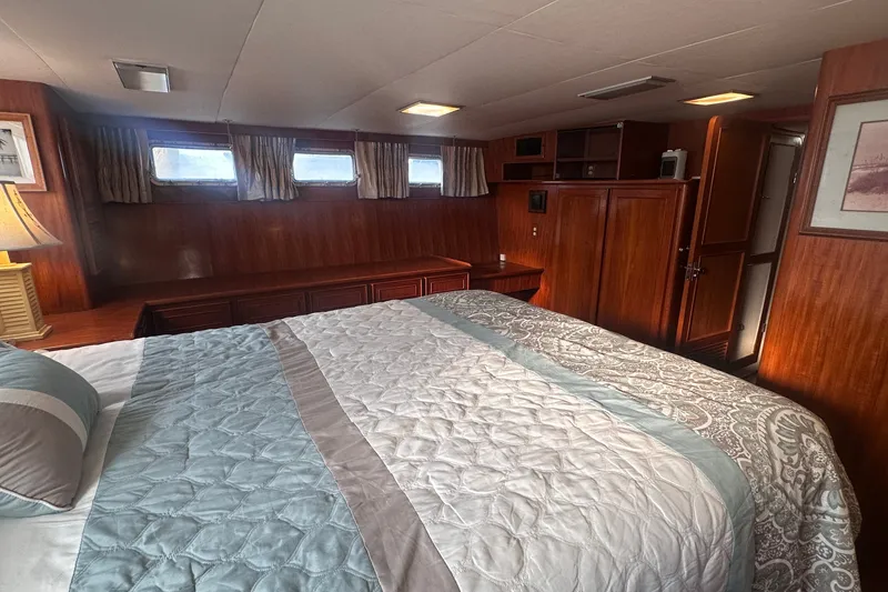 Slide: The Image of Luxurious bedroom interior of 1989 Jefferson Marquessa 52 yacht with wood paneling and cozy bedding. - 31