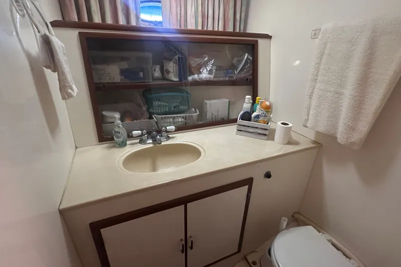 Slide: The Image of Bathroom interior of 1989 Jefferson Marquessa 52 yacht, featuring sink, mirror, and toiletries. - 22