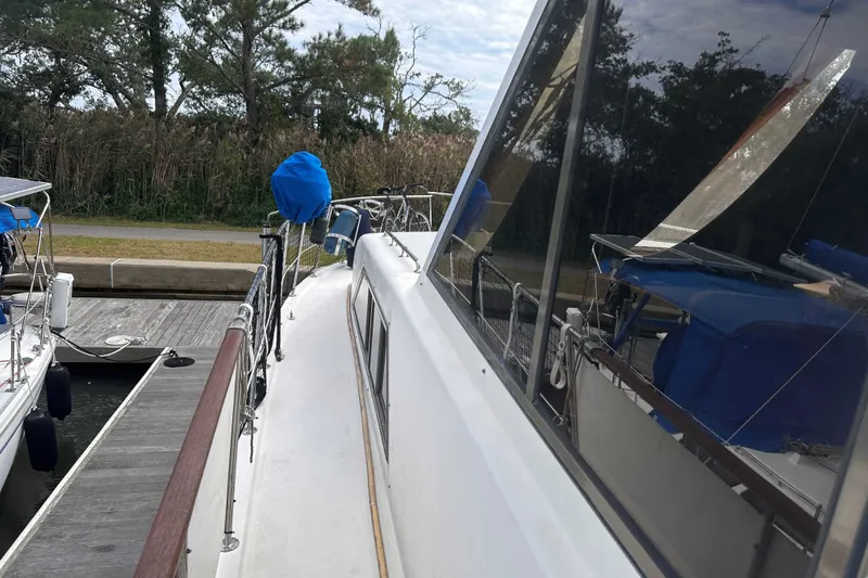 Slide: The Image of 1989 Jefferson Marquessa 52 yacht docked, featuring sleek design and reflective windows. - 3