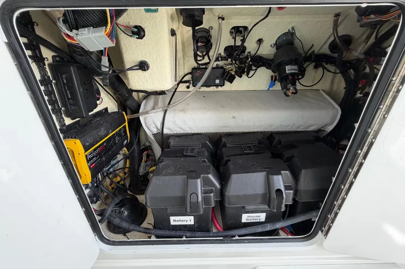 Slide: The Image of Electrical compartment of a 2023 Regulator 31 boat with batteries and wiring. - 38