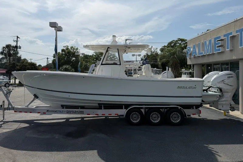Slide: The Image of 2023 Regulator 31 boat on trailer at dealership, side view. - 7