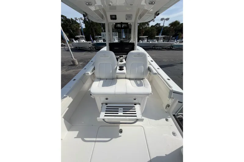 Slide: The Image of 2023 Regulator 31 boat interior with white seating and console, docked outdoors. - 21