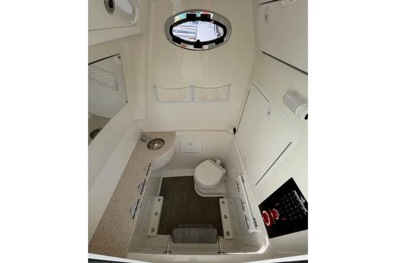 Slide: The Image of 2023 Regulator 31 boat interior cabin with toilet, sink, and storage compartments. - 34