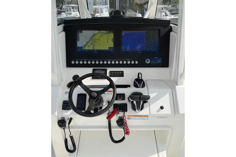 Slide: The Image of 2023 Regulator 31 boat dashboard with navigation screens and steering wheel. - 13