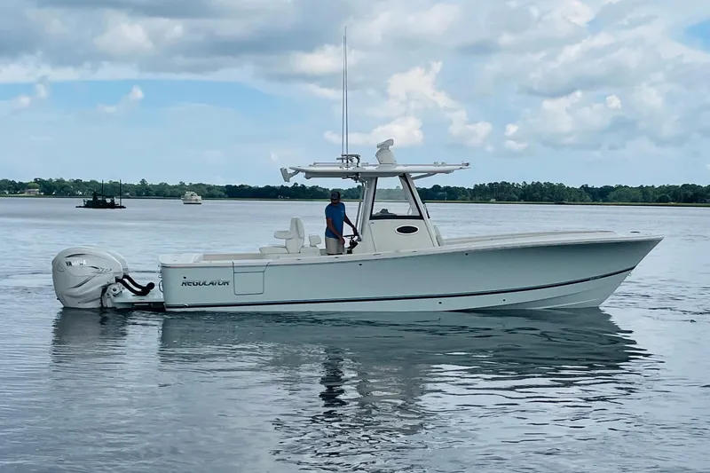 Slide: The Image of 2023 Regulator 31 boat on calm water under cloudy sky. - 1