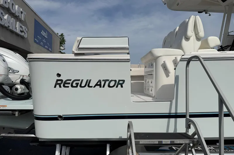 Slide: The Image of 2023 Regulator 31 boat at dealership, showcasing sleek design and seating area. - 10