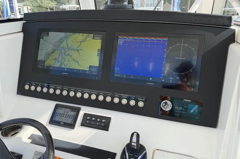 Slide: The Image of 2023 Regulator 31 boat dashboard with Garmin navigation displays and control panel. - 14