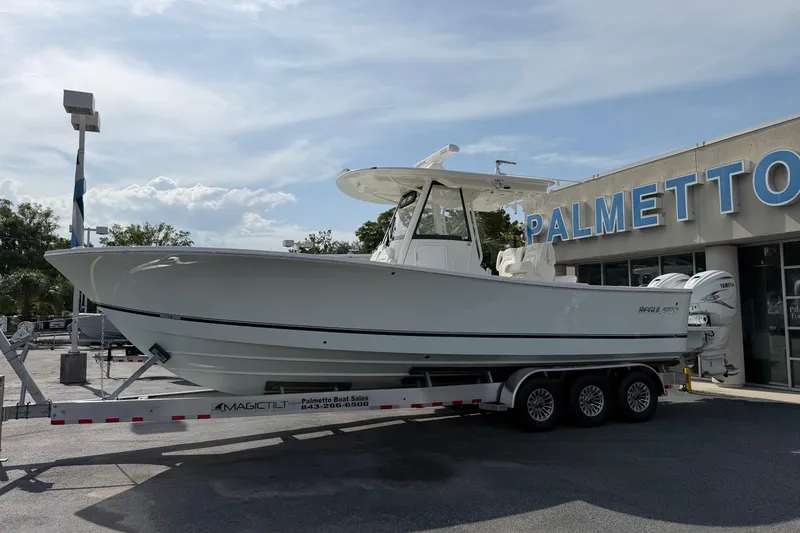 Slide: The Image of 2023 Regulator 31 boat on trailer at Palmetto dealership under a clear sky. - 8