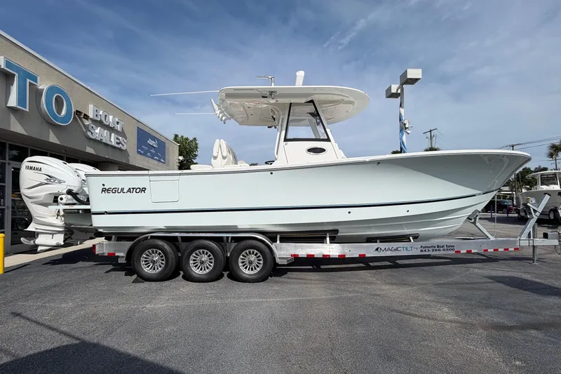 Slide: The Image of 2023 Regulator 31 boat on trailer at dealership, featuring Yamaha engines. - 5