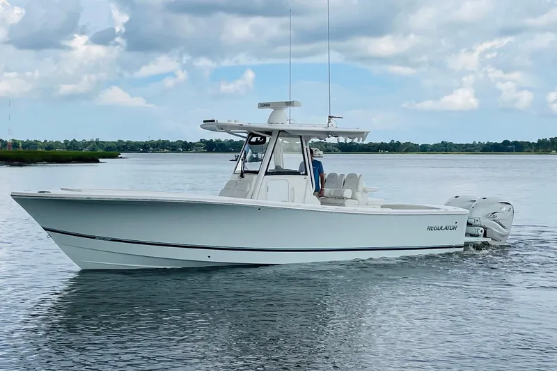 The Image of 2023 Regulator 31 boat cruising on calm water under a partly cloudy sky. - 0