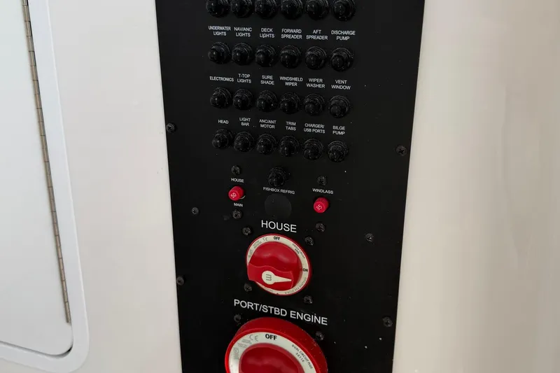 Slide: The Image of Control panel of a 2023 Regulator 31 boat with various switches and dials. - 37
