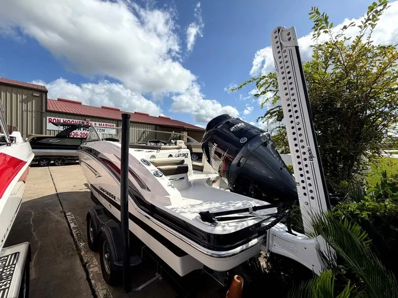 Slide: The Image of A white 2019 Chaparral boat on a trailer beside a building. The sky is partly cloudy. - 25