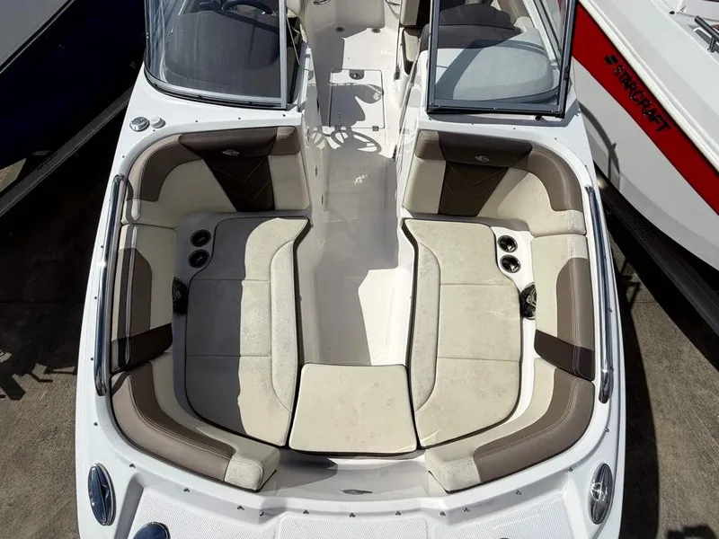 Slide: The Image of Chaparral 2019 boat with beige and brown upholstery, open bow area, surrounded by other boats. - 18
