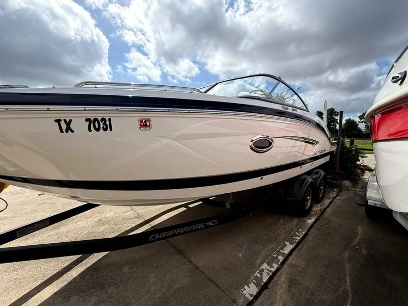 Slide: The Image of A 2019 Chaparral boat on a trailer. It features a white hull with black accents. - 24