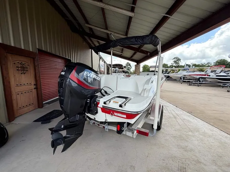 Slide: The Image of A white boat with an Evinrude motor sits on a trailer in a covered area. - 3