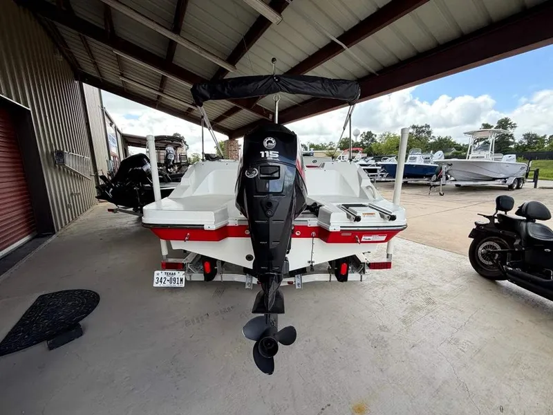 Slide: The Image of A 2020 Godfrey boat with an outboard motor, parked under a covered area. - 4