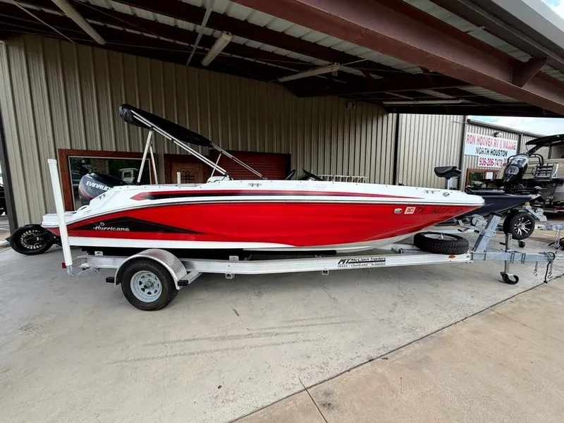 Slide: The Image of A red 2020 Godfrey boat on a trailer, parked in a covered area. - 2