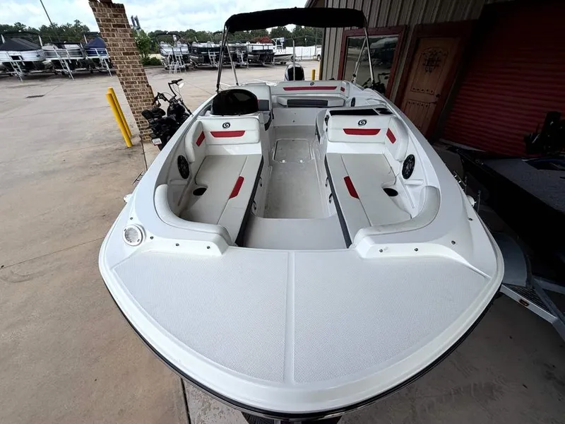 Slide: The Image of A white 2020 Godfrey boat with red accents, parked in a warehouse. - 8