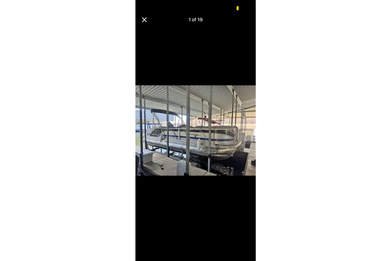 The Image of 2022 South Bay 25 CTS pontoon boat docked in a covered marina. - 1