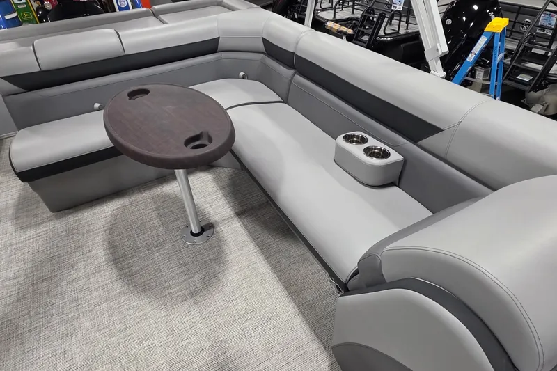 Slide: The Image of 2022 South Bay 25 CTS pontoon boat interior with gray seating and round table. - 25