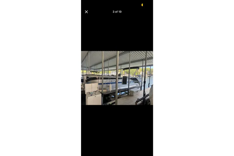 Slide: The Image of 2022 South Bay 25 CTS pontoon boat docked under a covered marina. - 3
