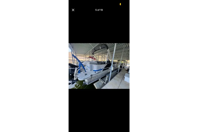 Slide: The Image of 2022 South Bay 25 CTS pontoon boat docked under a covered marina. - 5