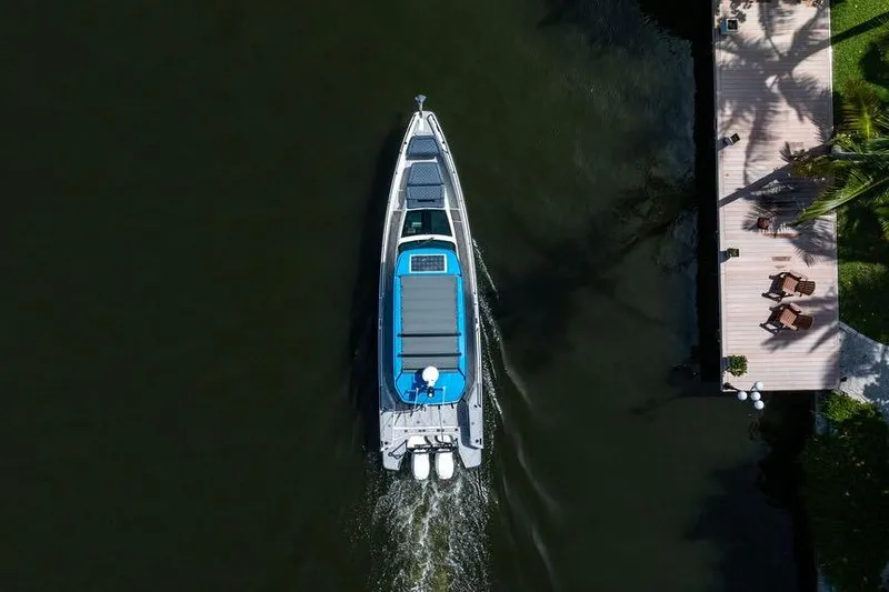 Slide: The Image of Overhead view of 2021 Axopar Brabus 37 Sun-Top boat cruising near a dock. - 5
